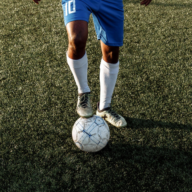 Soccer player with his foot on the ball after recovering from nutcracker injury.